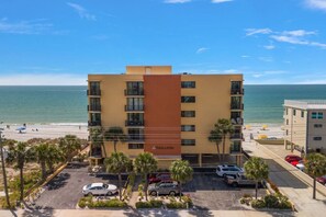 A hotel with a modern design, located near a beach with a view of the ocean.