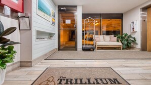L’entrée d’un hôtel, avec un comptoir d’accueil, un espace d’attente doté d’un canapé et une porte bien visible qui mène à l’intérieur.