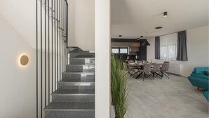 Un interno moderno con una scala, zona pranzo e soggiorno.