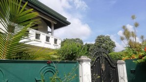 A gated property with a white building and a green gate. - Blossoms Apartment (Ragama)