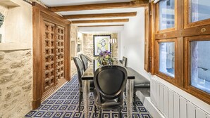 A dining area with a long table, black chairs, and a patterned floor. - Aquipic, 2BR/1BA, 4 people (París)