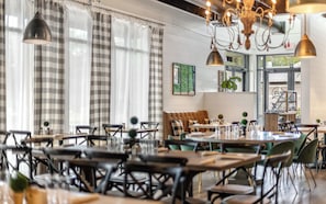 A restaurant with multiple tables and chairs, a chandelier, and a view of the outside. - Single Level WaterColor Home - Steps to Seaside - 3 Bikes (Santa Rosa Beach)