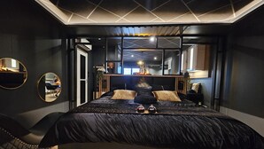 Un dormitorio moderno con una cama grande, un cabecero de madera y un tragaluz.