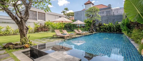 Una piscina al aire libre, sombrillas, tumbonas