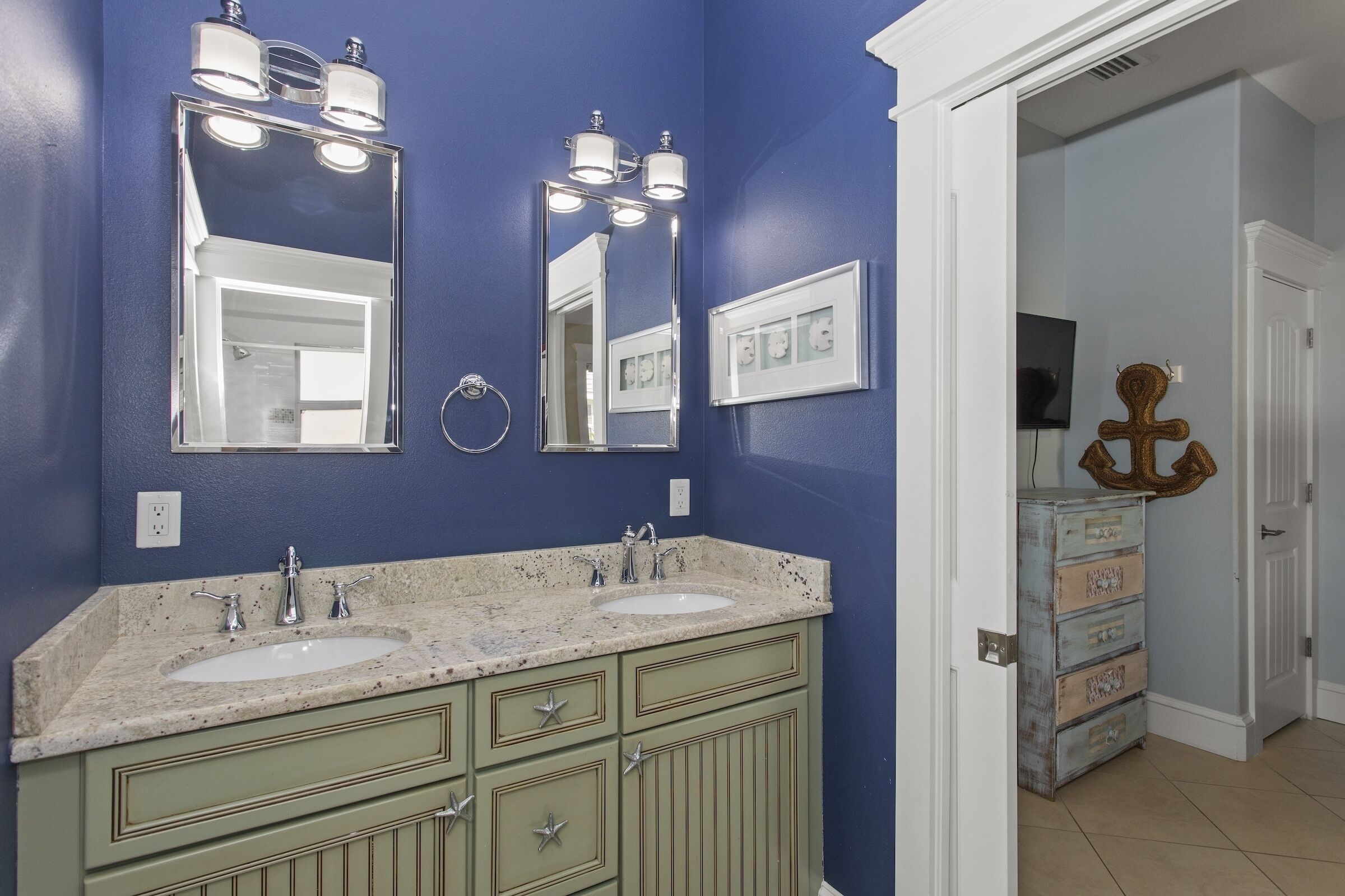 A bathroom with two sinks, a mirror, and a vanity with drawers.