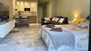 A modern hotel room with a bed, bedside table, and a small desk area with a chair. - Banus Elegant Modern Estudio Next to the Beach (Marbella)