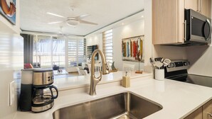 Eine moderne Küche mit Edelstahlgeräten, einer großen Spüle und einem Deckenventilator.