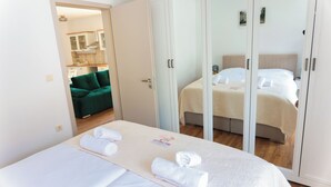 Een hotelkamer met een bed, een kledingkast en uitzicht op de keuken en woonkamer.