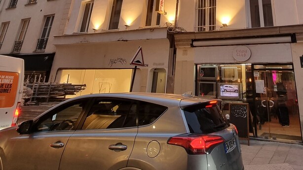 A multi-story hotel with illuminated windows and a sign indicating it is a hotel. - Hôtel Aboukir (Paris)