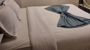 A hotel room with a neatly made bed, a framed picture on the wall, and a shelf with toiletries. - Hôtel Aboukir (Paris)