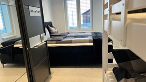 A compact bedroom with a bed, a desk, and a window. - Ferienwohnung am Schönen Walensee in der Nähe der Gondelbahn Flumserberg (Unterterzen)