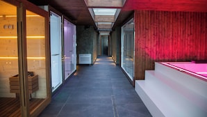 Un spa moderne doté d ’une verrière, de murs en bois et d’un espace sauna entièrement vitré.