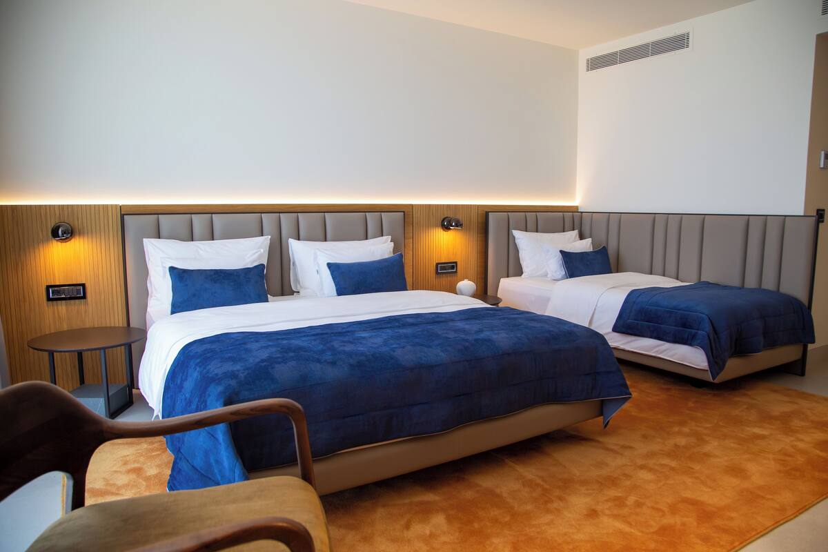 Ein Hotelzimmer mit zwei Betten, einem kleinen Tisch und einem Stuhl.