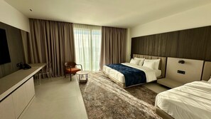 A hotel room with a bed, a desk, a chair, and a TV.