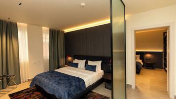 Una habitación de hotel moderna con una cama grande, un escritorio y una zona de estar separada.