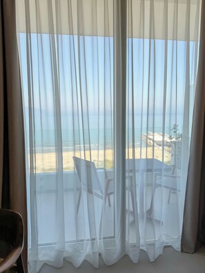 A room with a view of the beach through sheer curtains, a table, and chairs. - Abi's Hotel & SPA Vlore (Vlorë)