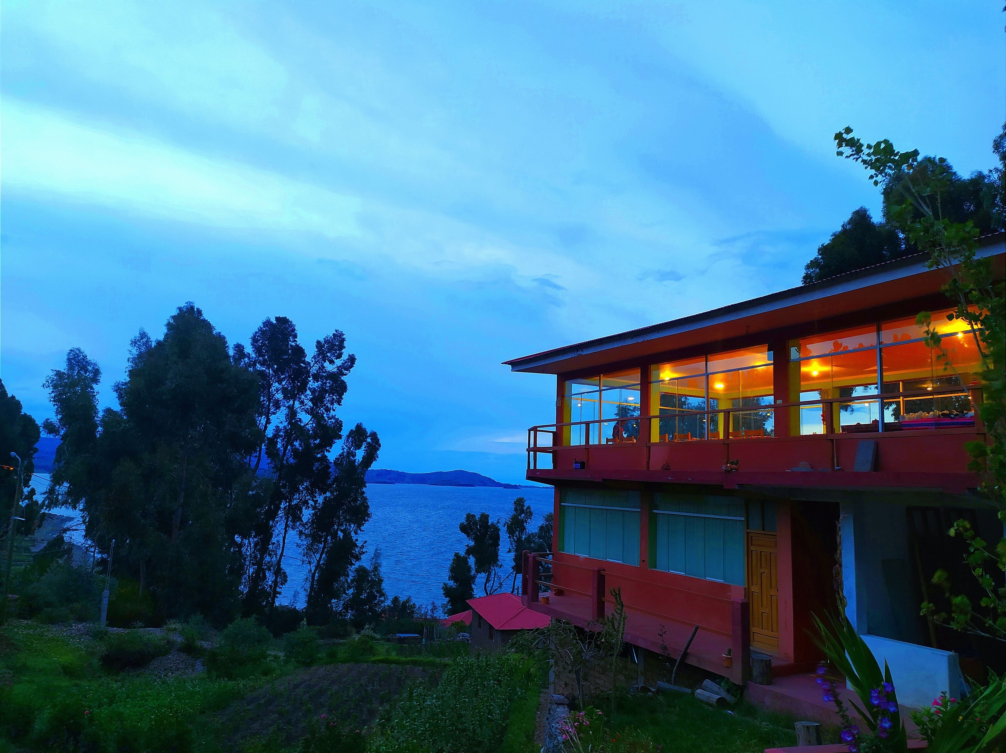 A two-story building with large windows, a balcony, and a view of the sea.