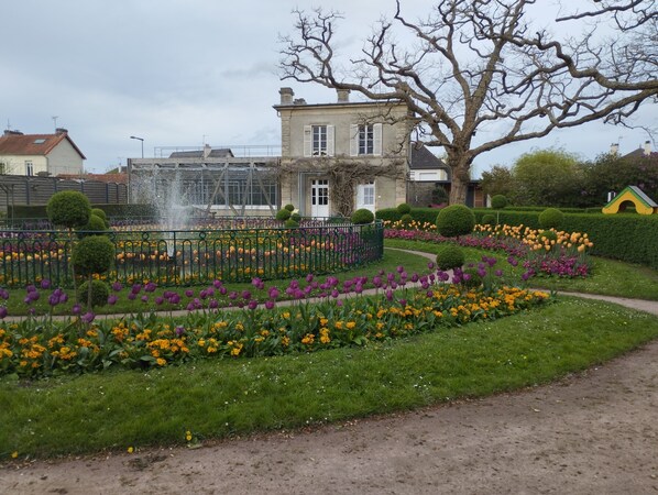 Stroll through the beautifully maintained garden, featuring a variety of colorful flowers and a serene fountain.