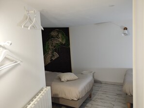 Cozy retreat with a single bed, white radiator, and ceiling fan.