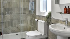 Ein Badezimmer mit einer Duschkabine, einer Toilette und einem Waschbecken.