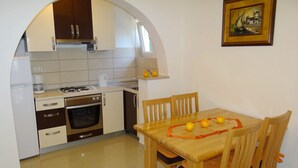 Cocina compacta con comedor, que incluye estufa, horno y cafetera.