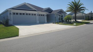 A residential house with a garage, a driveway, and a well-maintained lawn.