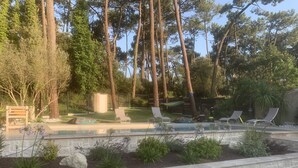 A pool area with lounge chairs, a wooden bench, and a hammock. - Maison Avec Piscine. Animaux de Compagnie Acceptés (La Tremblade)