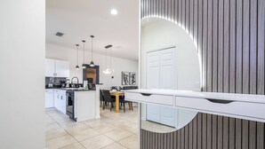 A modern kitchen with white cabinets, a central island, and pendant lighting. - Cozy, perfect for families, Hot Tub - 3013 (Kissimmee)