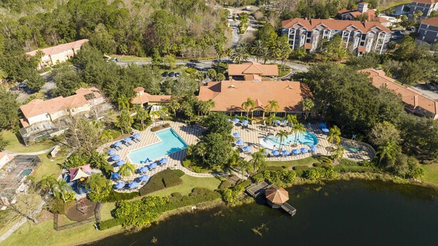 An aerial view of a resort with multiple swimming pools, a dock, and a lake. - Cozy, perfect for families, Hot Tub - 3013 (Kissimmee)
