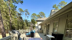 A wooden deck with a table and chairs, a barbecue grill, and a covered seating area. - Private Sea Pines Home w Large Deck. Great for couples! (Hilton Head Island)