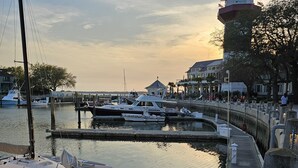A marina with boats docked, a lighthouse, and a waterfront promenade. - Private Sea Pines Home w Large Deck. Great for couples! (Hilton Head Island)