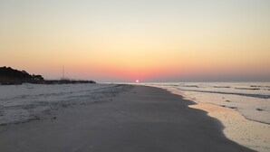 A beach at sunset with a clear sky and calm sea. - Private Sea Pines Home w Large Deck. Great for couples! (Hilton Head Island)