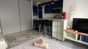 Eine moderne Küche mit Barbereich, einem Flachbildfernseher und einem Bücherregal.