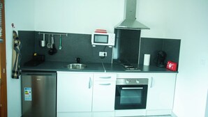 A compact kitchen with a dishwasher, oven, microwave, and stove. - Log'Appart, calm, comfort, wifi AUDENGE (Audenge)