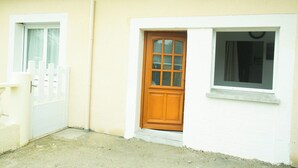 A house with a wooden front door, a white picket fence, and a window with a curtain. - Log'Appart, calm, comfort, wifi AUDENGE (Audenge)