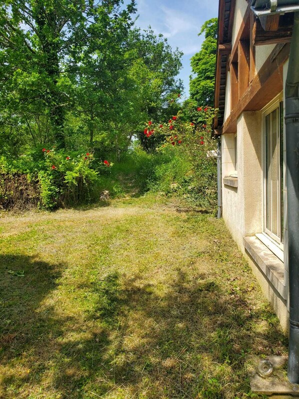 A grassy yard with a building on the right. - Dans le val de Loire, Gite de Charme Pour 4 Personnes au Château de La Noue (Villedômer)