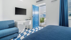 Una habitación de hotel moderna con una cama grande, un escritorio, una silla y un televisor.