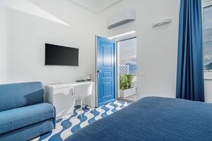 Una habitación de hotel moderna con una cama grande, un escritorio, una silla y un televisor.