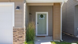 A house with a front door, a garage, and a small porch area. - Stationary bike|1600ft²|Backyard|Parking|300Mbps (Nampa)