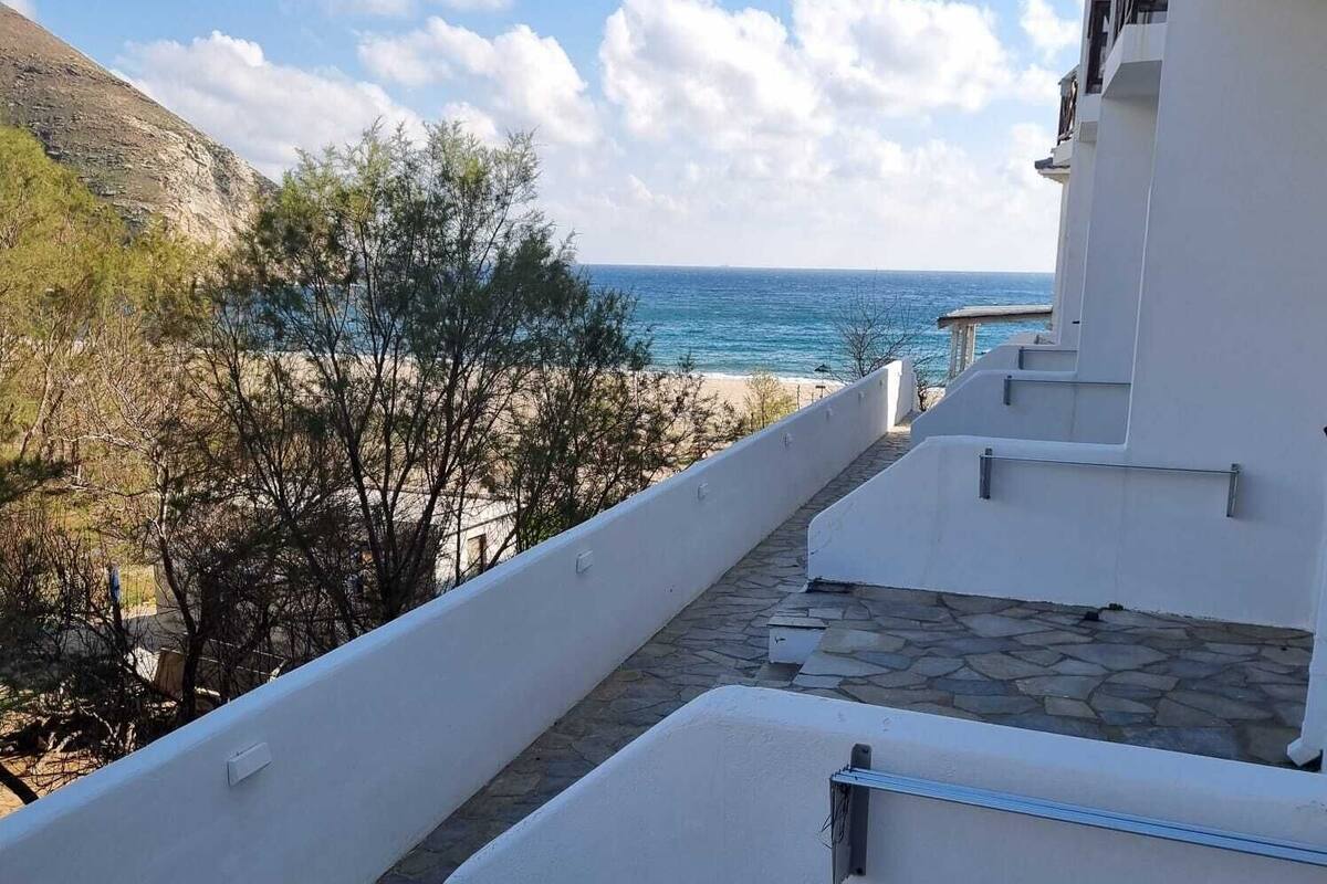 Ein weißes Gebäude mit einem Steinweg, der zum Strand führt.