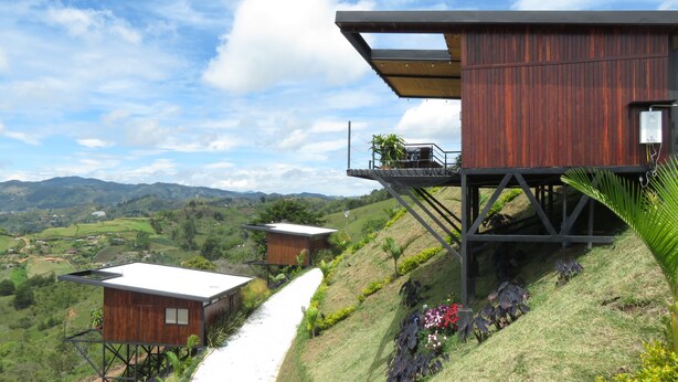 Una propiedad en una ladera con cabañas de madera y un sendero.