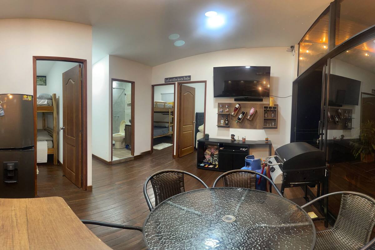 A compact living space with a dining area, a kitchen, and a small bathroom.
