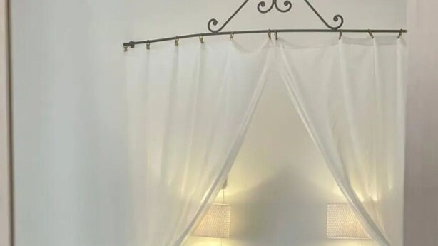 A bed with a canopy, white bedding, and two rolled towels. - Big fish Affittacamere (Alghero)