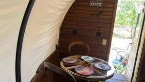 Una pequeña habitación de madera con una mesa, sillas y vistas al exterior.