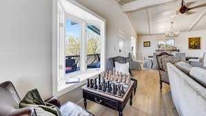 Ein großzügiges Wohnzimmer mit einem großen Schachbrett, einer Couch und einem Essbereich mit Tisch und Stühlen.