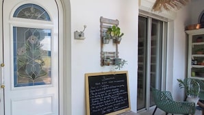 A door with a stained glass design, a chalkboard with a welcome message, and a small plant shelf. - Character house with swimming pool (Bergerac)
