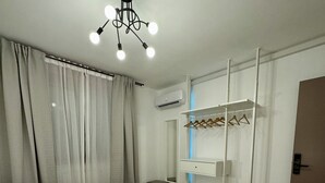 Een moderne hotelkamer met een groot bed, een plafondlamp, een kledingkast en een spiegel.