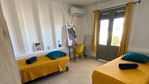 A room with two beds, a desk, and a chair.