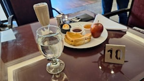 A dining table with a glass of water, a plate with toast, jam, and an apple, and a small sign with the number 10. - Le caire guest  (Cairo)