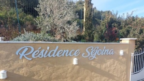 Señalización para 'Résidence Séjona', con pared beige y letras blancas.